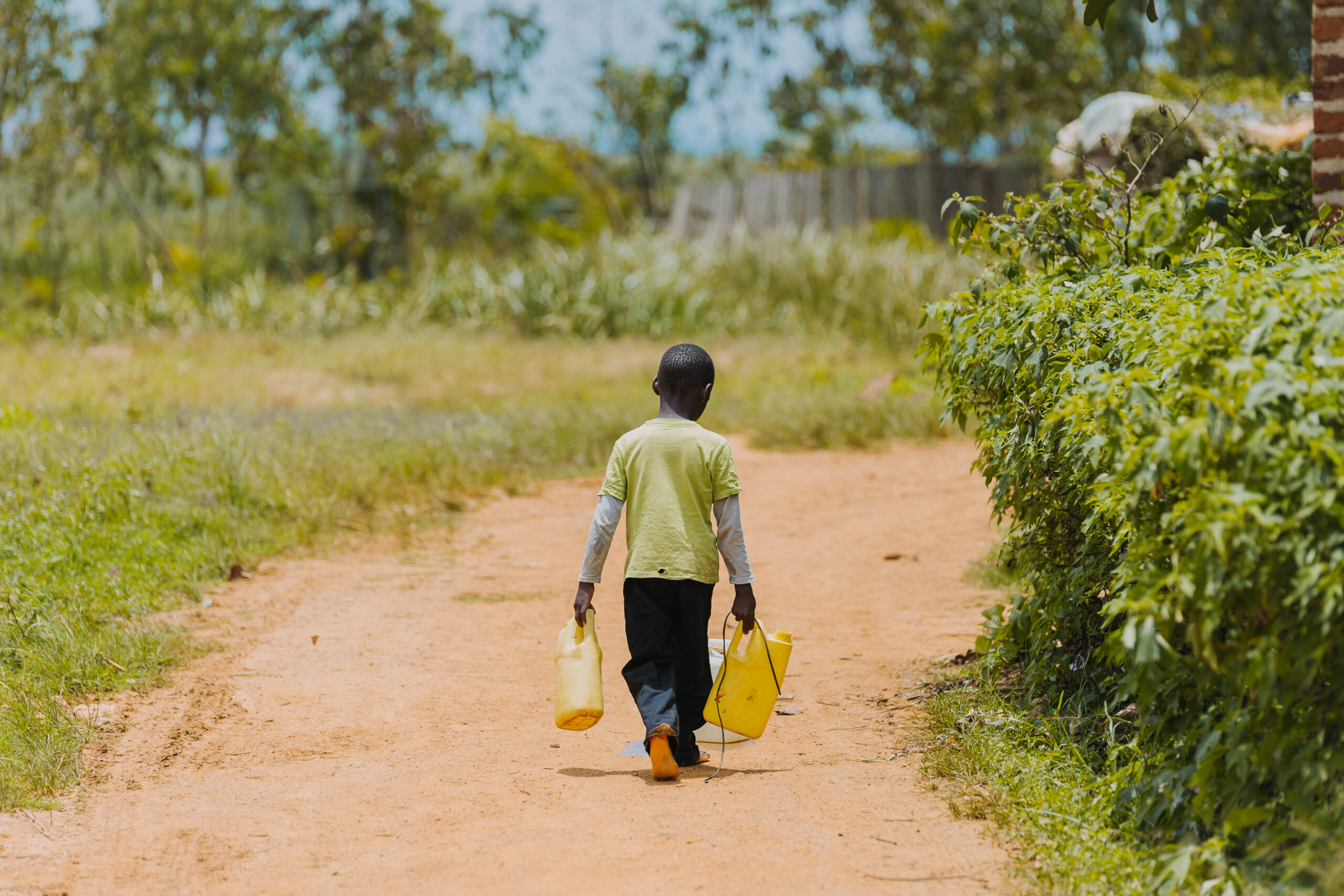 Child,Carrying,Water,In,Uganda,,Africa