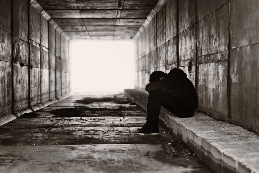 A,Lonely,Boy,Sits,On,A,Curb,On,The,Right