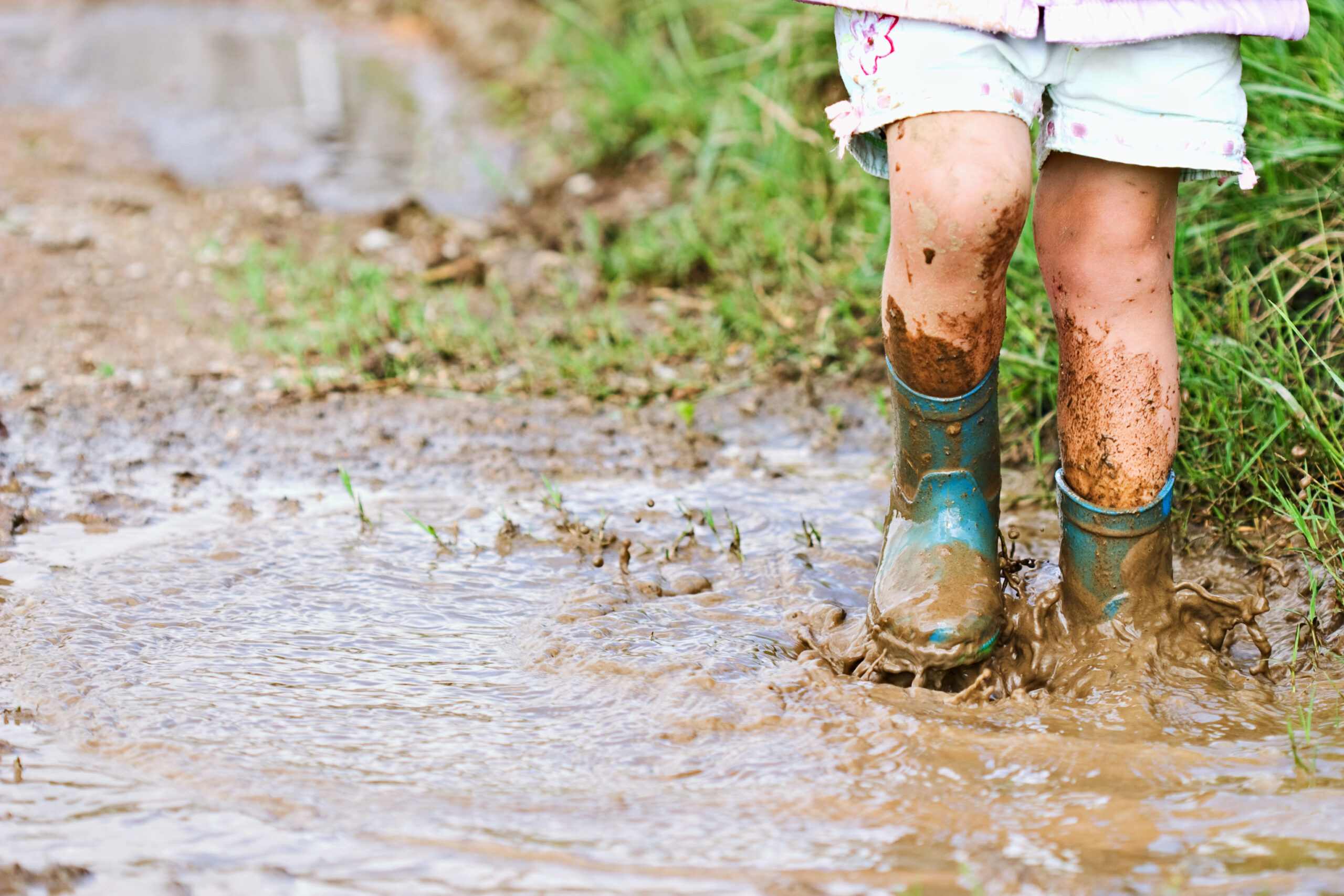 Child’s,Feet,Stomping,In,A,Mud,Puddle.